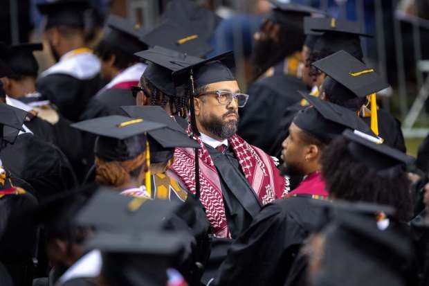 A graduate wears a keffiyeh and faces away from President Joe Biden in protest of the war in Gaza at the commencement ceremony at Morehouse College in Atlanta on Sunday, May 19, 2024. (Arvin Temkar/The Atlanta Journal-Constitution/TNS)