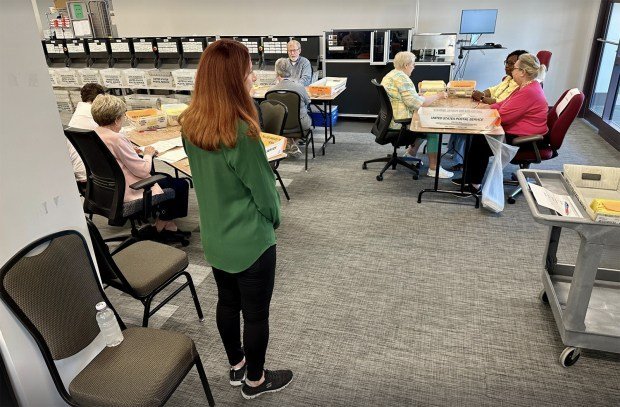 Seçim gözlemcileri 'Kasım ayındaki büyük dans' için gergin bir şekilde antrenman yapıyor 3 A Republican monitor overlooks the opening of absentee ballot envelopes at the Cobb County elections office in Marietta, Georgia, on the Monday before the May primary. (Matt Vasilogambros/Stateline/TNS)