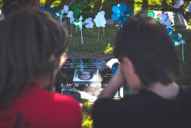 Fentanil krizinde bebekler ve yürümeye başlayan çocuklar şüphesiz kurbanlar haline geliyor 1 Two people look at a grave marker