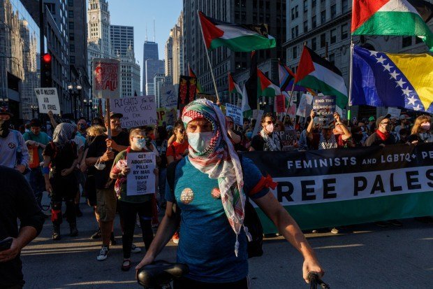 Activists march on North Michigan Avenue on Aug. 18, 2024, in Chicago, host city for the Democratic National Convention. The protest was organized by CODEPINK, a women-led anti-war nonprofit that seeks to redirect tax dollars into health care, education and green jobs. (Armando L. Sanchez/Chicago Tribune)