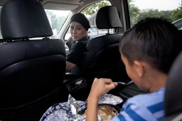 Herlinda Sanchez watches her son, Liam, eat breakfast as they wait outside for her chemotherapy appointment at Texas Oncology in San Antonio. (Lisa Krantz/KFF Health News/TNS)
